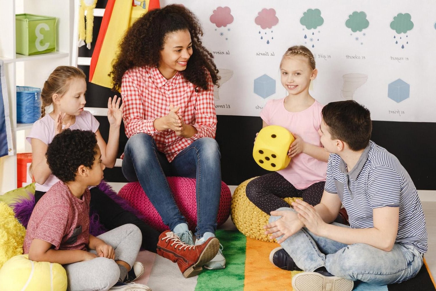 Teacher leading a small-group activity with children from different countries in a colourful classroom